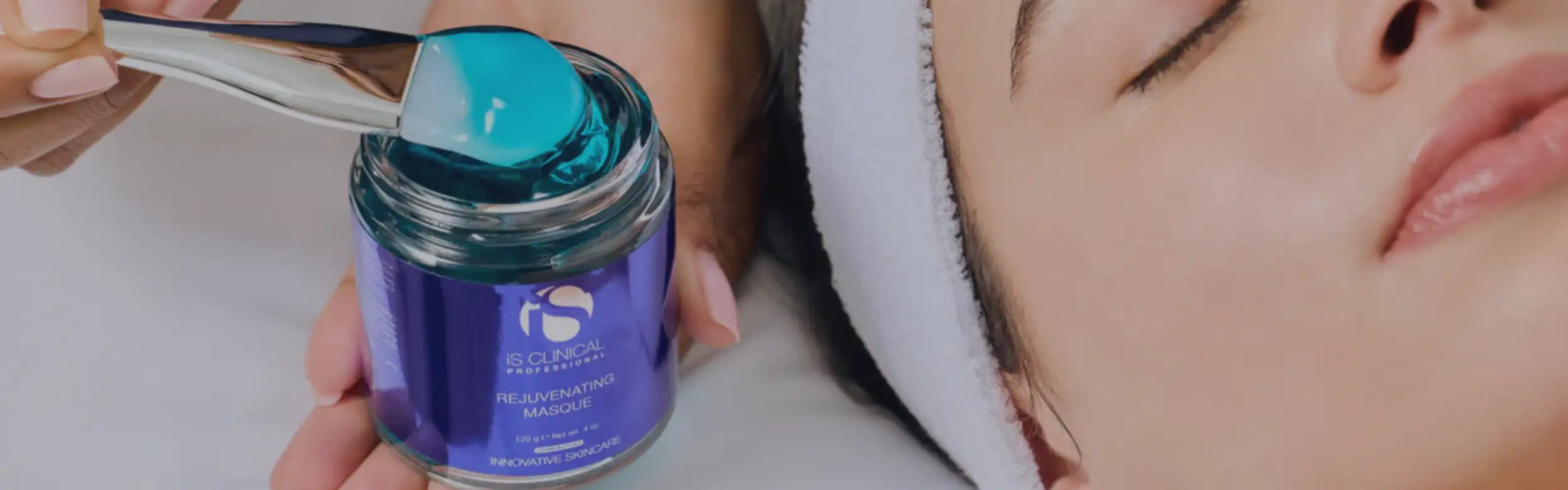 A blue, translucent gel mask in a clear glass jar with a purple label and silver spoon.