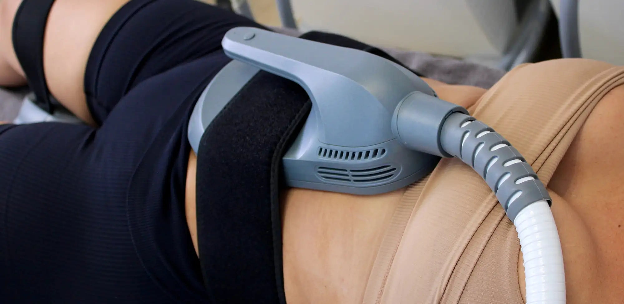 Gray plastic body with black straps, connected to a white and gray coiled tube.