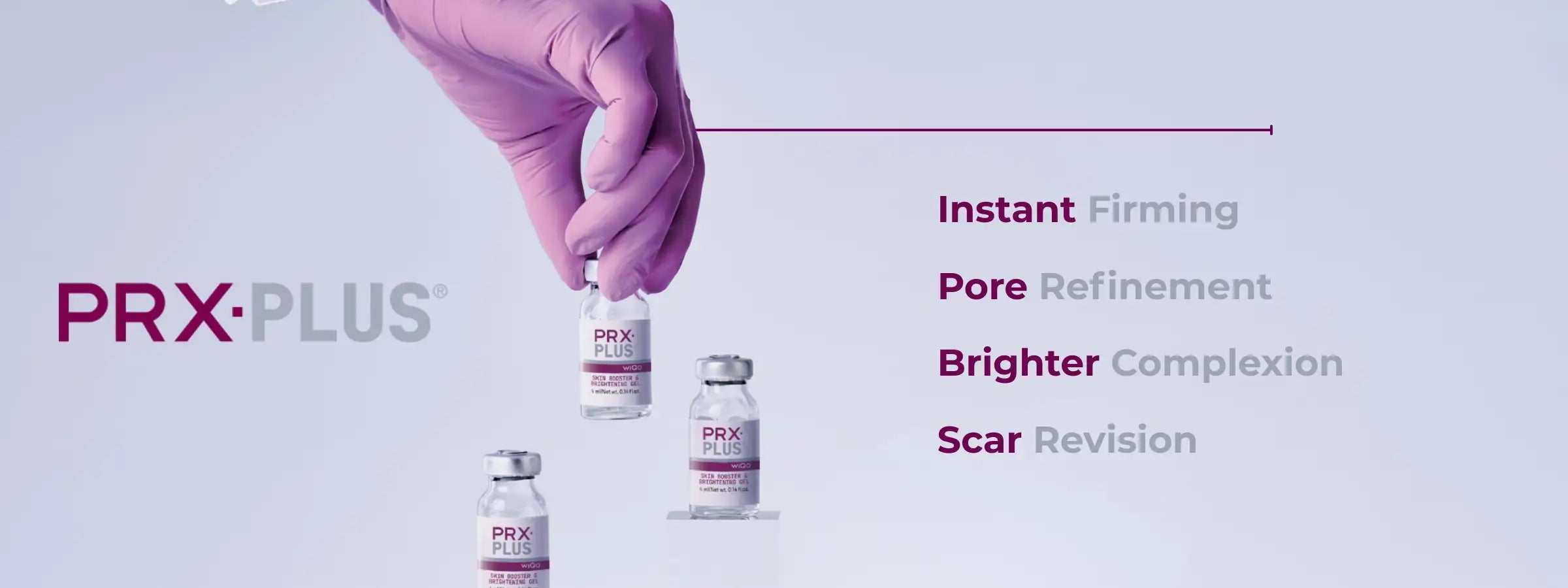 A hand in a purple glove holds a clear glass vial with a silver cap and pink label, labeled ’prx-plus,’ alongside two similar vials on the surface.