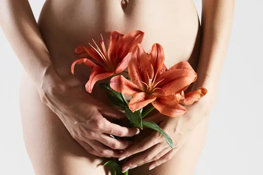 A pair of vibrant orange lilies with delicate speckled petals and green stems, held gently in hands.