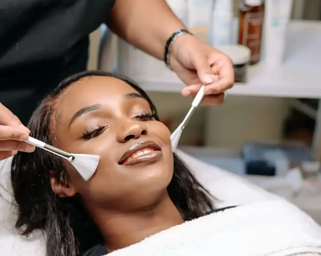 White facial cleansing brush with a sleek, ergonomic handle and soft bristles.