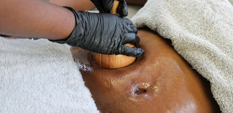 Wooden massage tool with a smooth, rounded head and a handle being used for therapy.